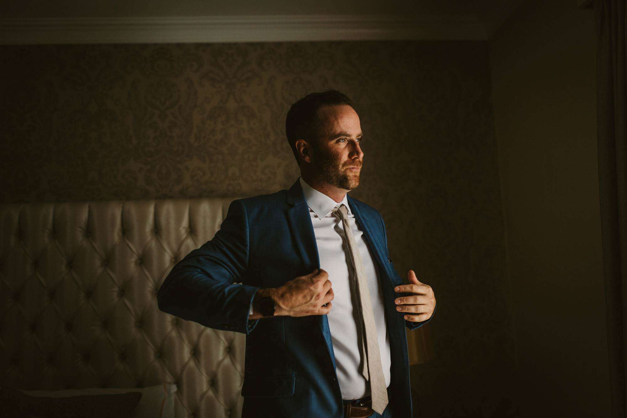 Elopement videographer Ireland , groom putting on navy blue jacket