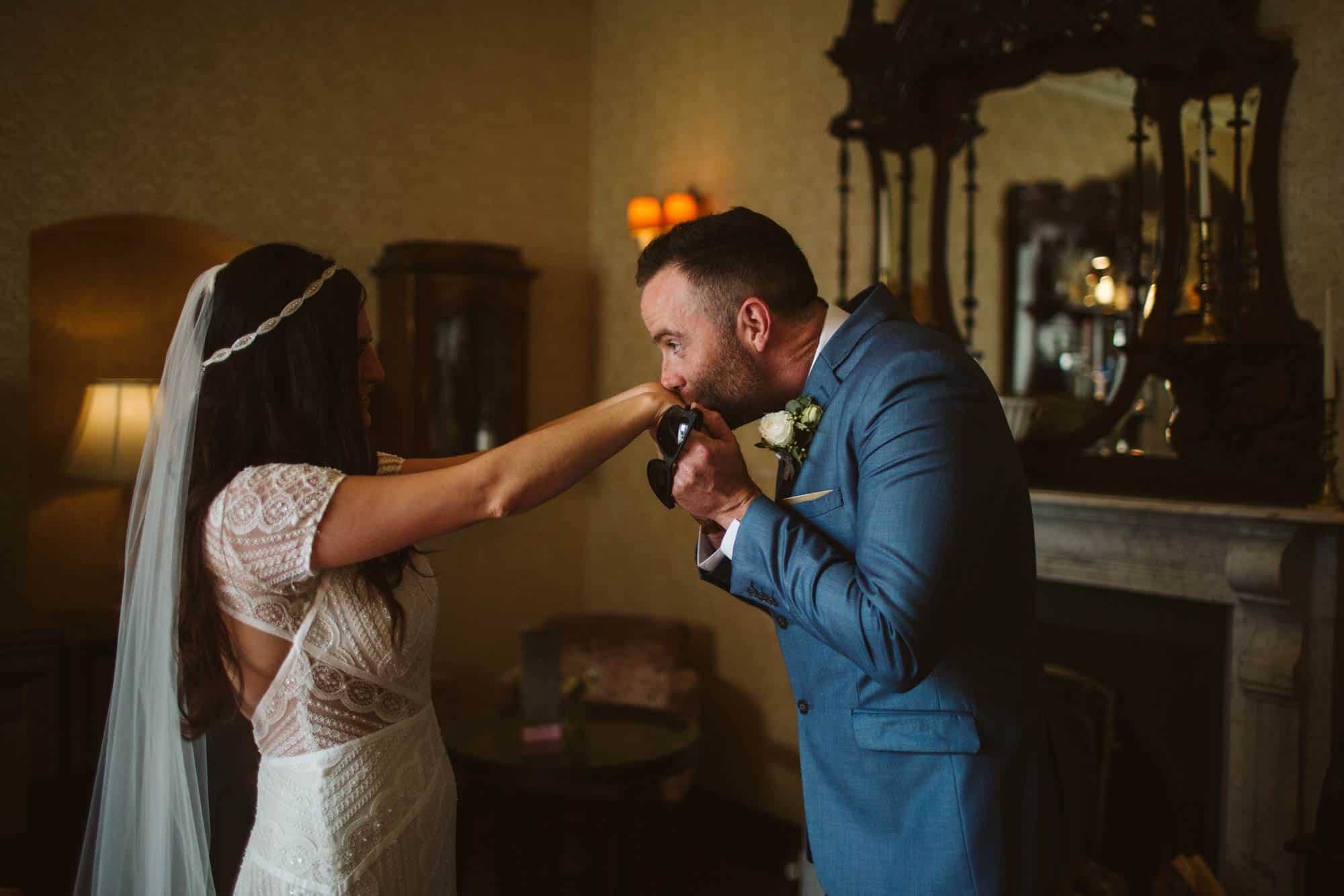 Elopement videographer Ireland, groom kisses brides hand
