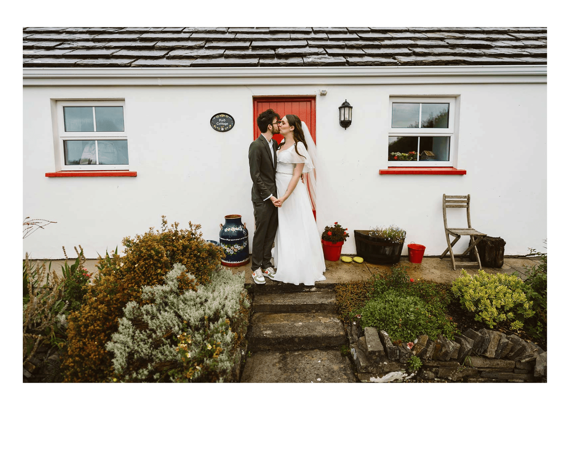 couple in front of cottage while eloping in Ireland
