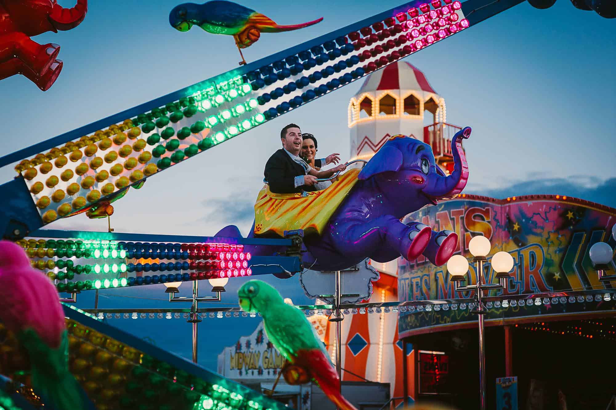 Fun on your Galway City Elopement, couple in leisureland on the elephants , laughing up in the sky after their celtic wedding ceremony